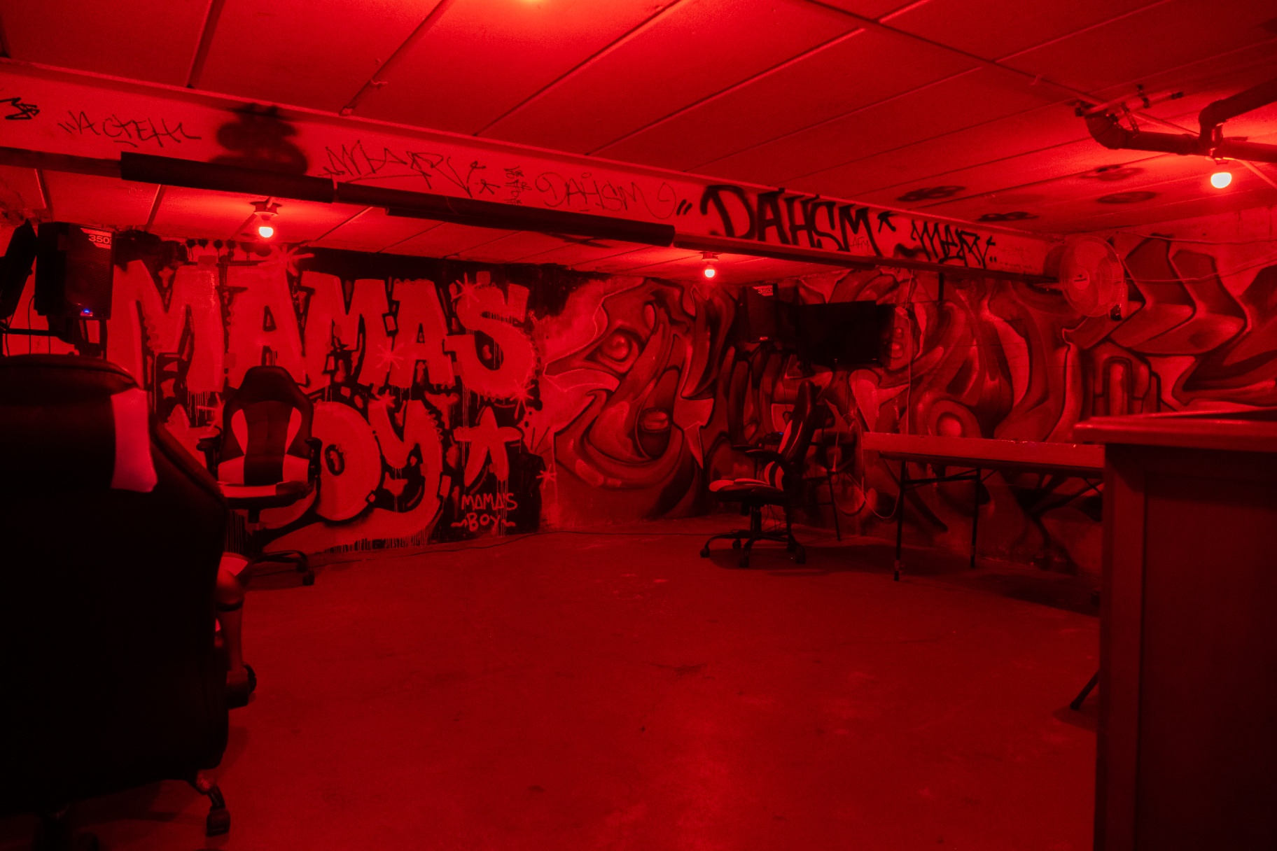 Mur graffiti Mama's Boy sous néons rouges